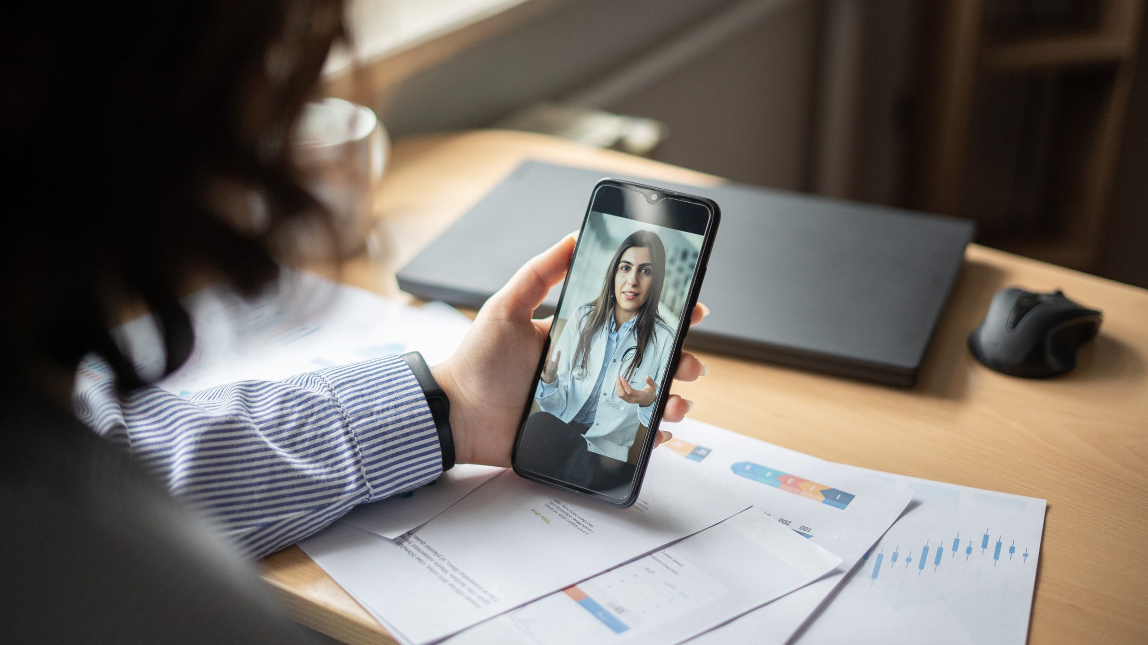 Businesswoman making video call with doctor in office
