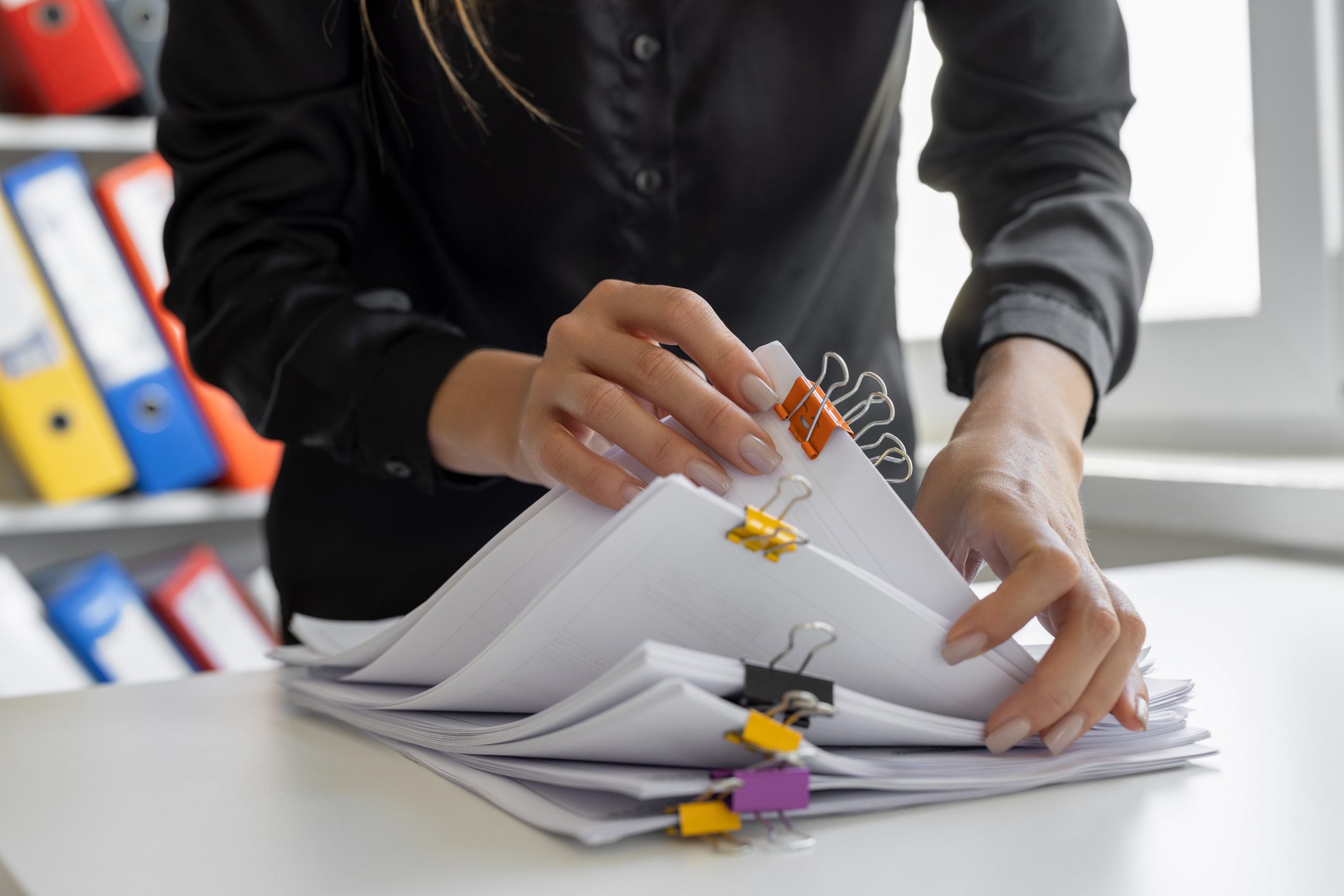 Businesswoman searching in stack of documents